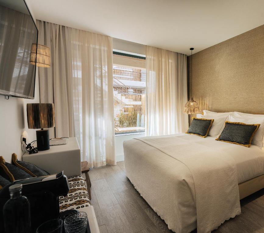 a bedroom with a large bed and a window at AlmaLusa Comporta in Comporta