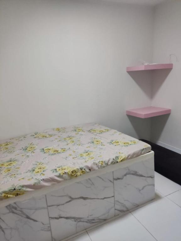 a bed in a room with a white wall at Casa de praia Carneiros-Tamandaré in Tamandaré