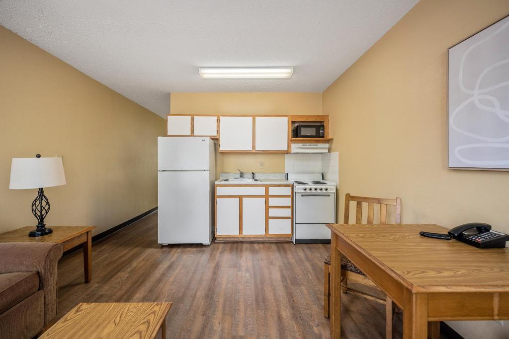 eine Küche mit einem weißen Kühlschrank und einem Tisch in der Unterkunft Affordable Suites Myrtle Beach in Myrtle Beach