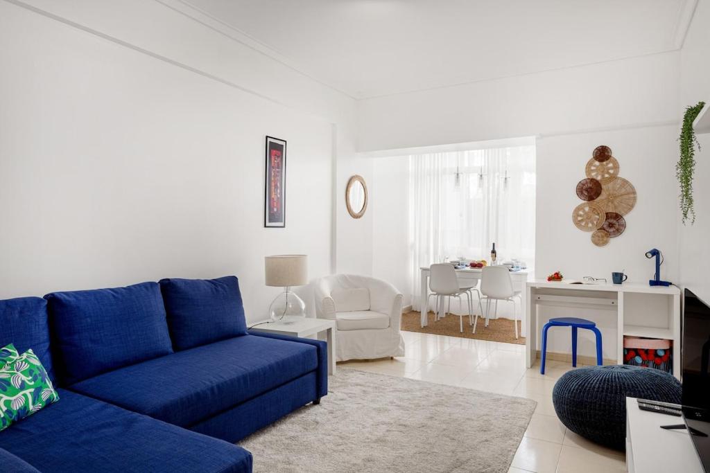 a living room with a blue couch and a chair at Luz & Mar at Coastal Oeiras in Oeiras