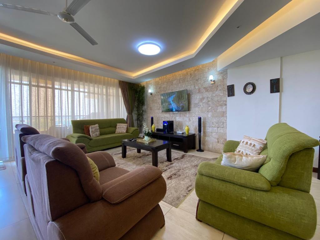 a living room with two couches and a fireplace at Seaview Comfort Apartment in Mombasa