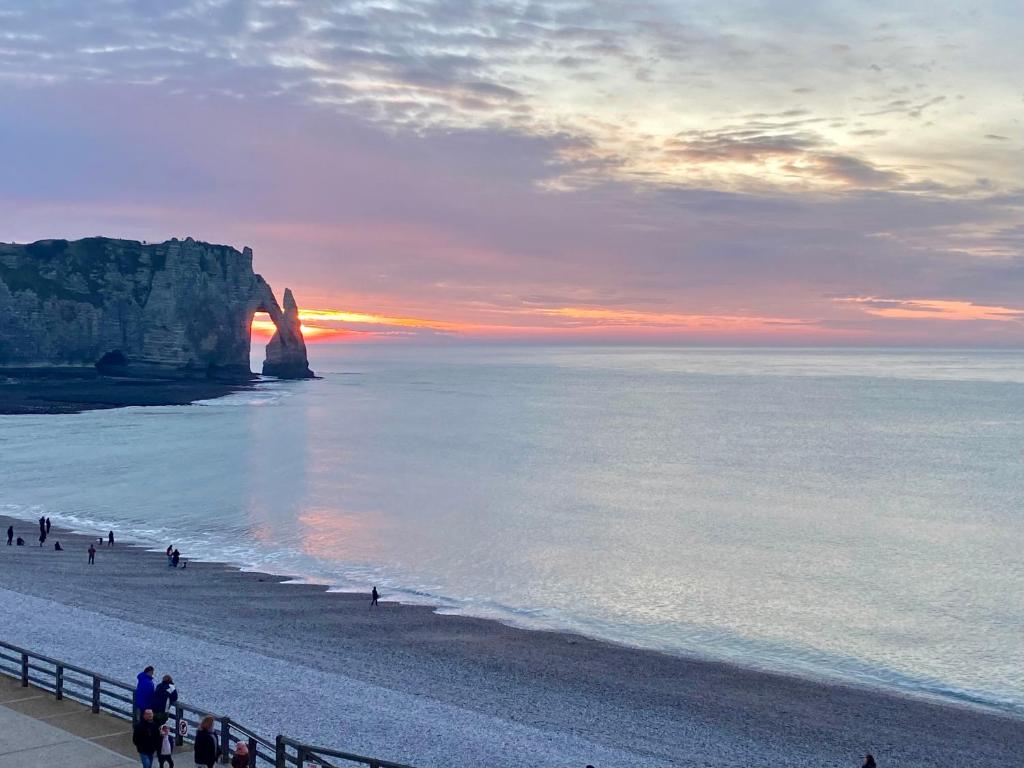 Un groupe de personnes marchant sur une plage près de l'océan dans l'établissement Grand appartement vue mer panoramique, à Étretat