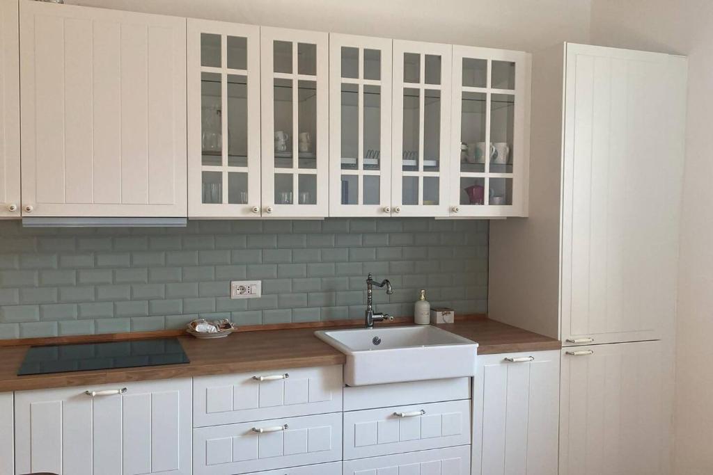 eine Küche mit weißen Schränken und einer Spüle in der Unterkunft Charme nel borgo - Appartamento Lina in Corniglio