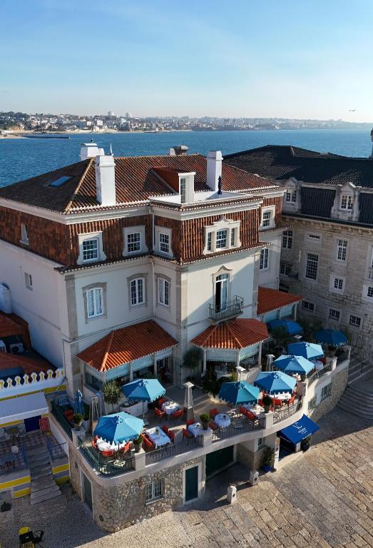 an aerial view of a building with tables and umbrellas at Villa Cascais Boutique Hotel in Cascais