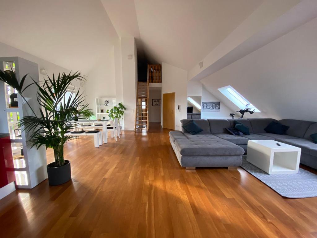 una sala de estar con un sofá y una mesa en Dachwohnung mit Sonnenterrasse, en Flörsheim