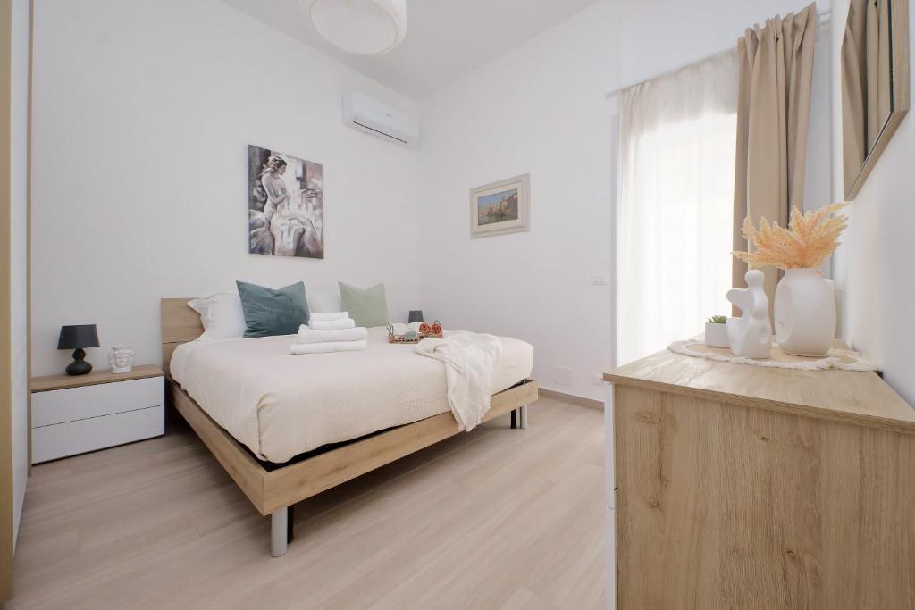 a white bedroom with a bed and a window at Elegante e Comodo - A pochi minuti dall'Aeroporto in Fiumicino