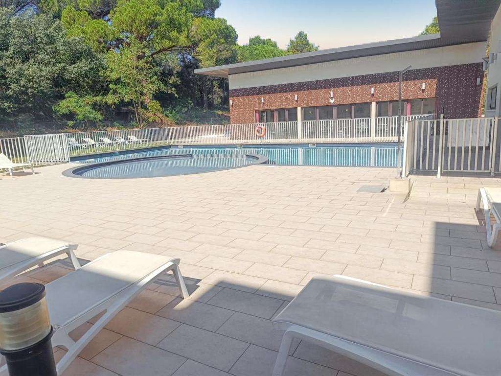 un patio avec une piscine dans un bâtiment dans l'établissement Appartement confortable à Remoulins, 49 m² avec piscine, à Remoulins
