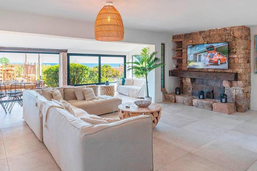 un salon avec un canapé et une cheminée dans l'établissement Villa Rocca Rossa vue exceptionnelle sur la mer, à Porto-Vecchio