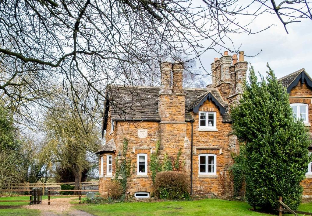una vieja casa de ladrillo con dos chimeneas en Park Cottage, en Glaston