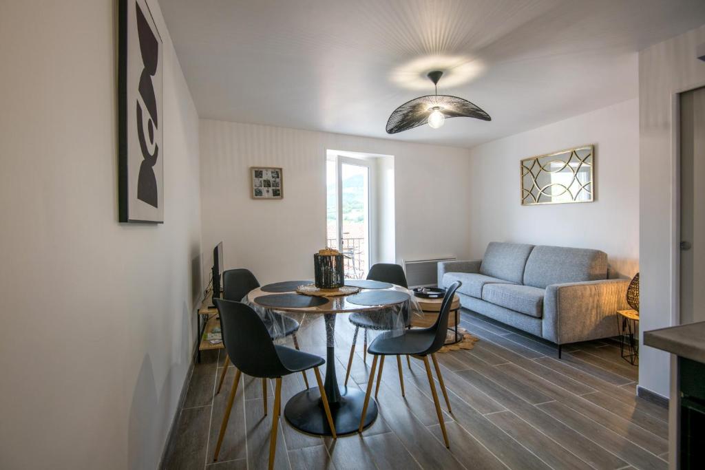 un salon avec une table, des chaises et un canapé dans l'établissement Panoramique balcon wifi centre-ville, à Millau