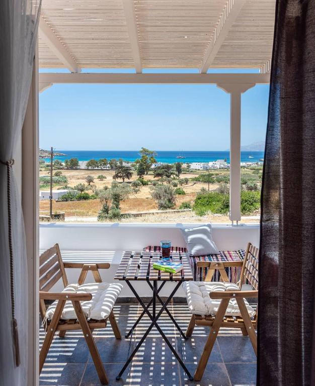 a table and chairs on a balcony with a view of the ocean at Mylopota apartment IIΙ in Mylopotas
