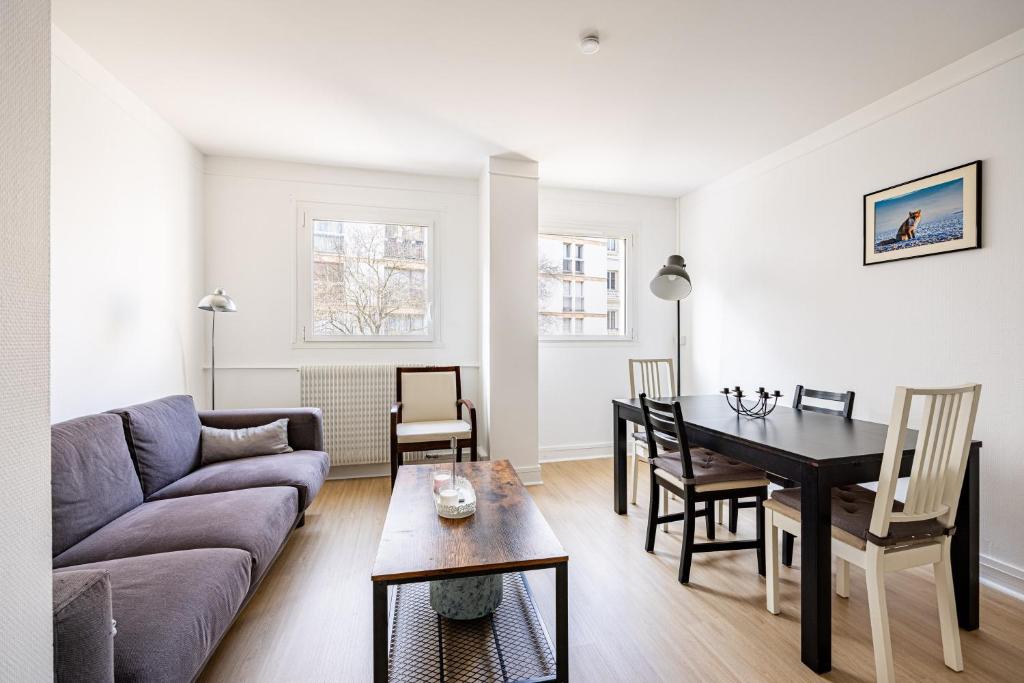 un salon avec un canapé et une table dans l'établissement L’Écrin Franklin - Proche Château de Versailles, à Versailles