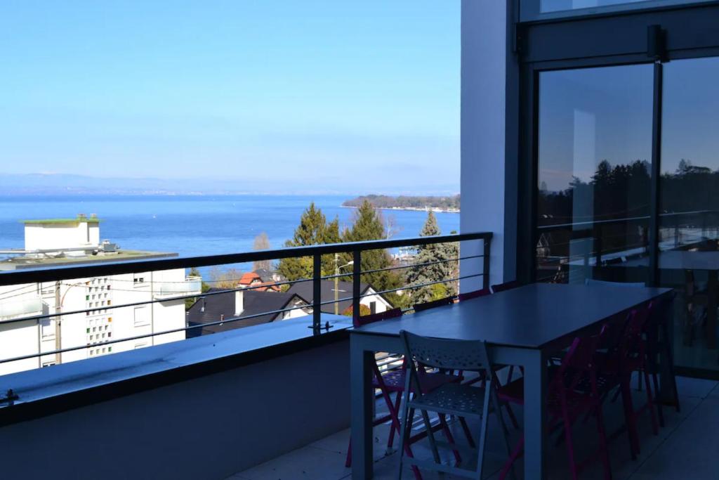 un balcon avec une table et des chaises et l'océan dans l'établissement Villa avec vue sur lac léman, à Thonon-les-Bains