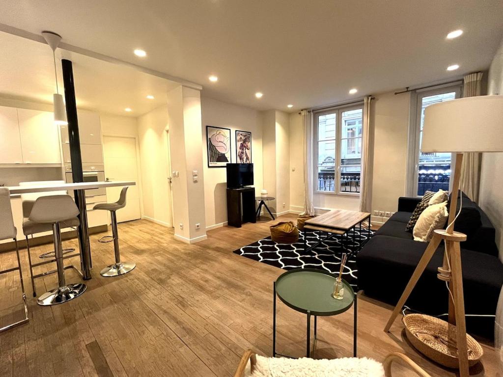 un salon avec un canapé et une table dans l'établissement GoodGuest Paris Montorgueil Bail Mobilité, à Paris