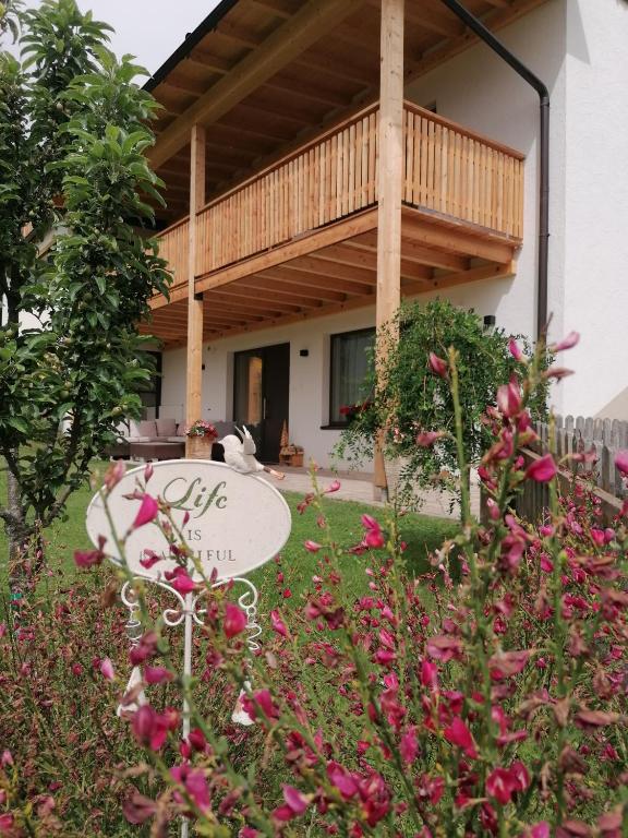 a garden in front of a house with pink flowers at Appartement Rehlein in Mauterndorf