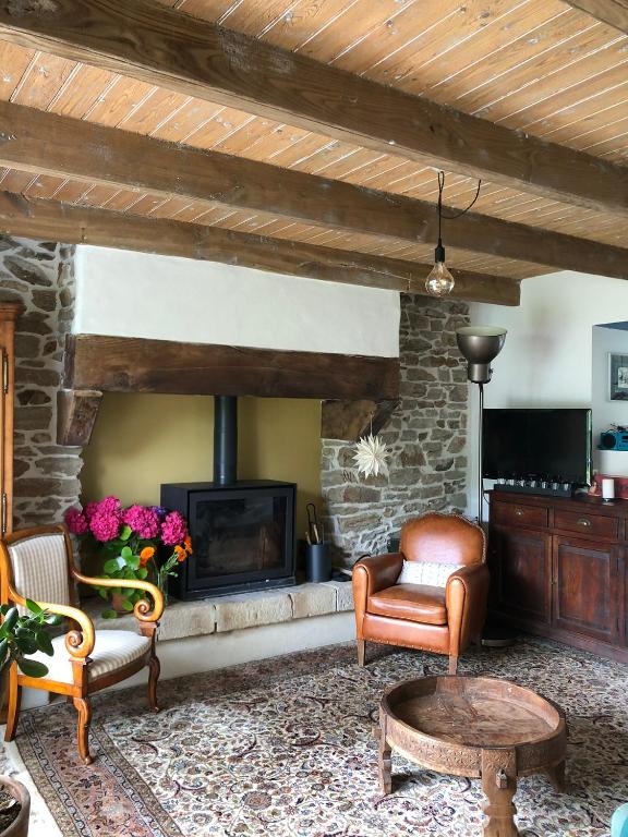 - un salon avec une cheminée en pierre et des chaises dans l'établissement Trouz An Dour, à Fouesnant