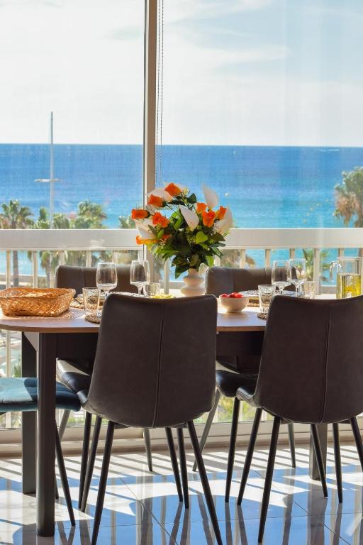 une table avec des chaises et un vase avec des fleurs dessus dans l'établissement Spacieux T2 au bord de l'eau, vue panoramique, à Six-Fours-les-Plages