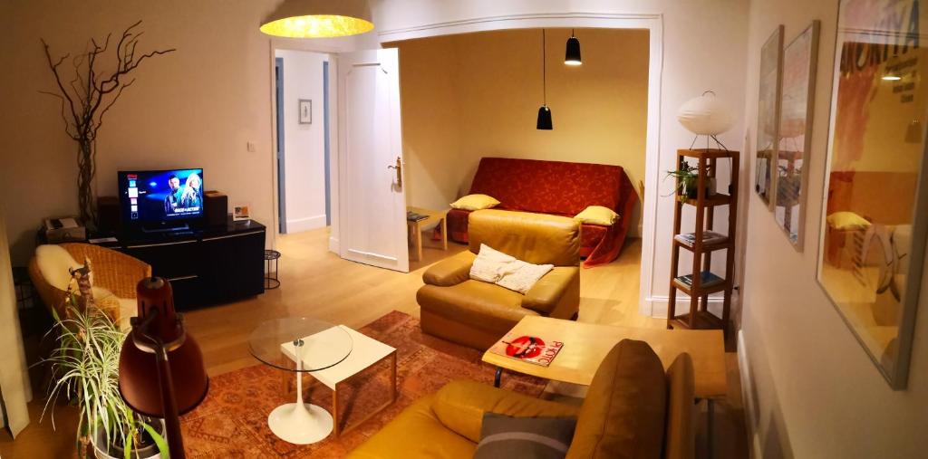 un salon avec un canapé et une télévision dans l'établissement Opus 14 privileged area in Burgundy, à Chalon-sur-Saône