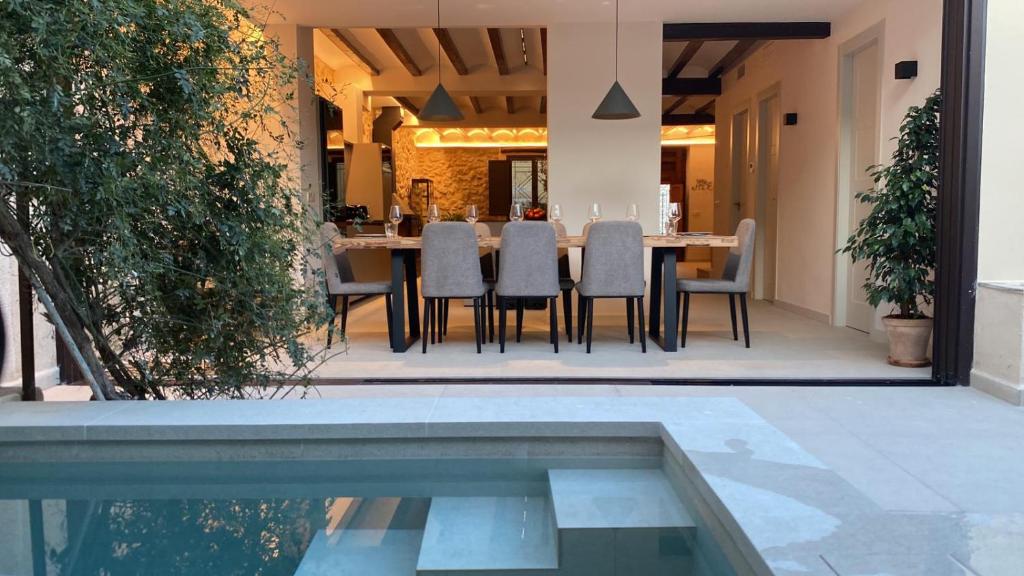a dining table and chairs next to a swimming pool at Casa Adela - Luxury Rural Accommodation in Castellonet