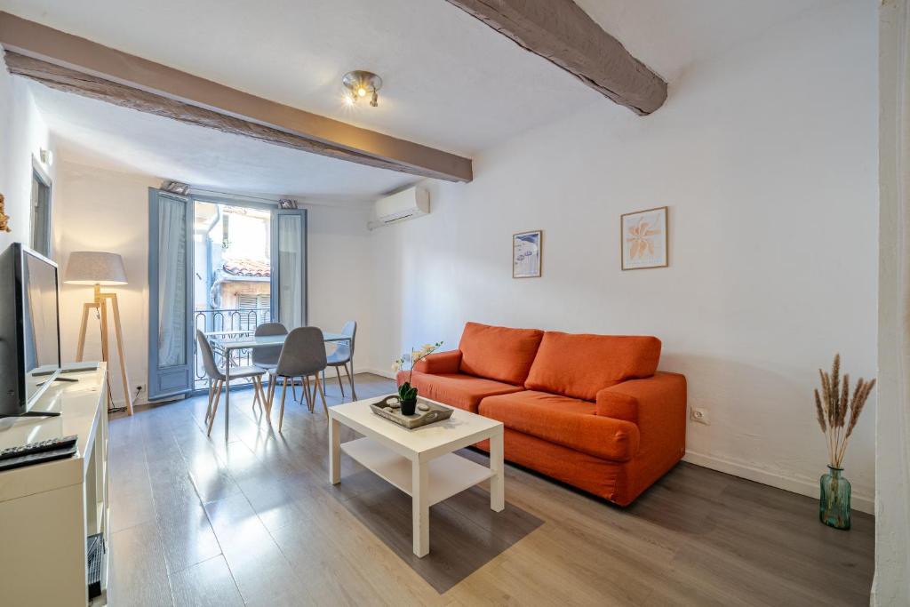 un salon avec un canapé orange et une table dans l'établissement Vieux-Nice 2P climatisé Balcon, à Nice