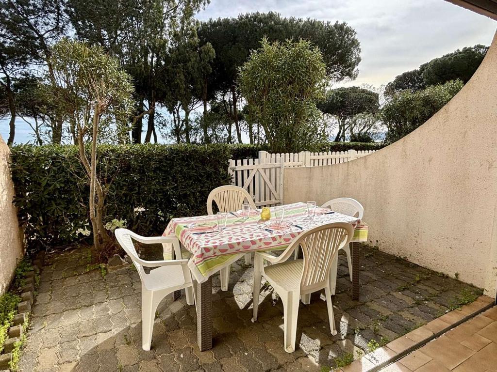 une table et des chaises assises sur une terrasse dans l'établissement Studio cabine cosy avec terrasse et accès direct plage, Argelès-sur-Mer - FR-1-225-595, à Argelès-sur-Mer