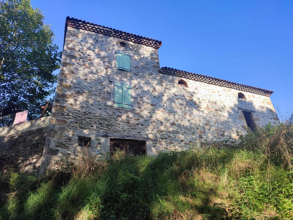 un ancien bâtiment en pierre au sommet d'une colline dans l'établissement Maison de campagne 60m2, à Tailhac