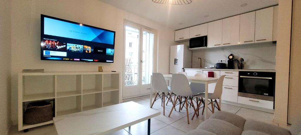 Il comprend une cuisine avec une table et une télévision murale. dans l'établissement 