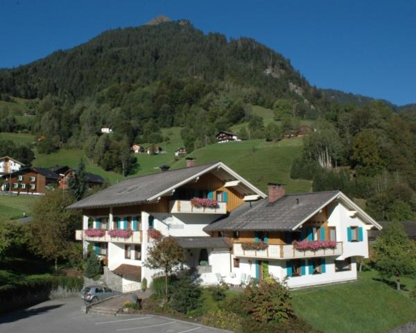 a large house on a hill with a mountain at Haus Platina in Sankt Gallenkirch