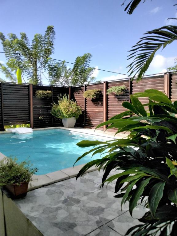 a swimming pool in a backyard with a fence at Grand T2 avec piscine privative in Les Trois-Îlets