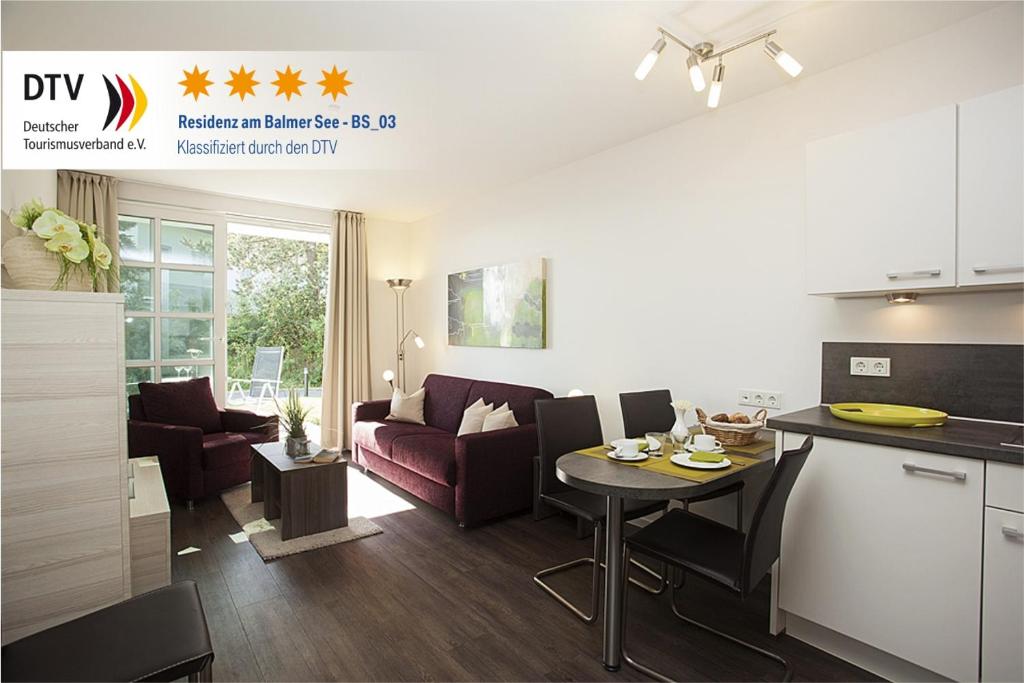 a kitchen and living room with a table and chairs at Residenz am Balmer See - BS 03 mit Wellnessbereich in Balm