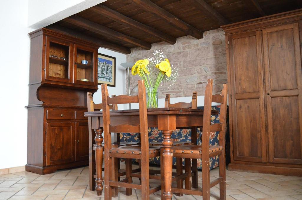 a dining room table and chairs with a vase of flowers at Residenza San Jacopo in Spello