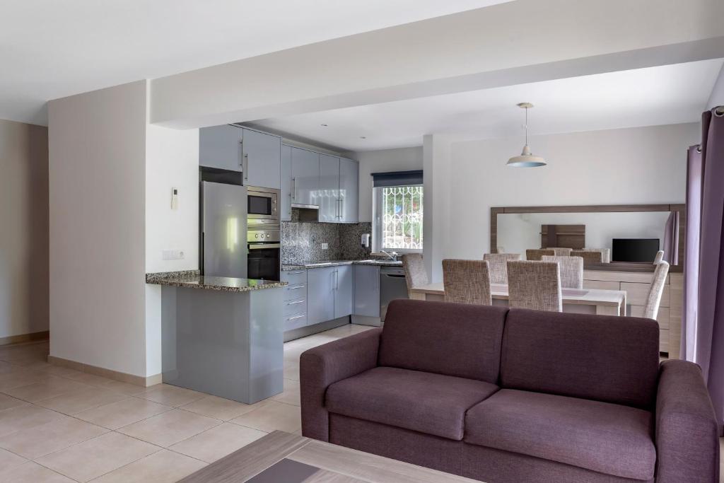 a living room with a couch and a kitchen at Vilar do Golf in Quinta do Lago