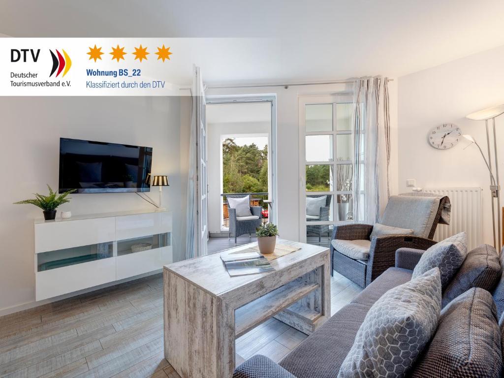 ein Wohnzimmer mit Sofa und Tisch in der Unterkunft Residenz am Balmer See - BS 22 mit Wellnessbereich in Balm