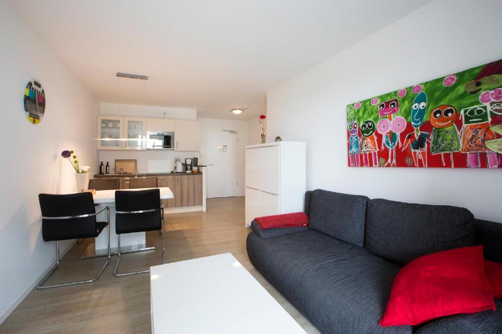 a living room with a couch and a kitchen at Residenz am Balmer See - BS 09 mit Wellnessbereich in Balm