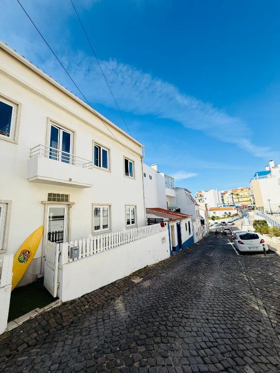 a street in a town with a white building at 70's Hostel in Ericeira