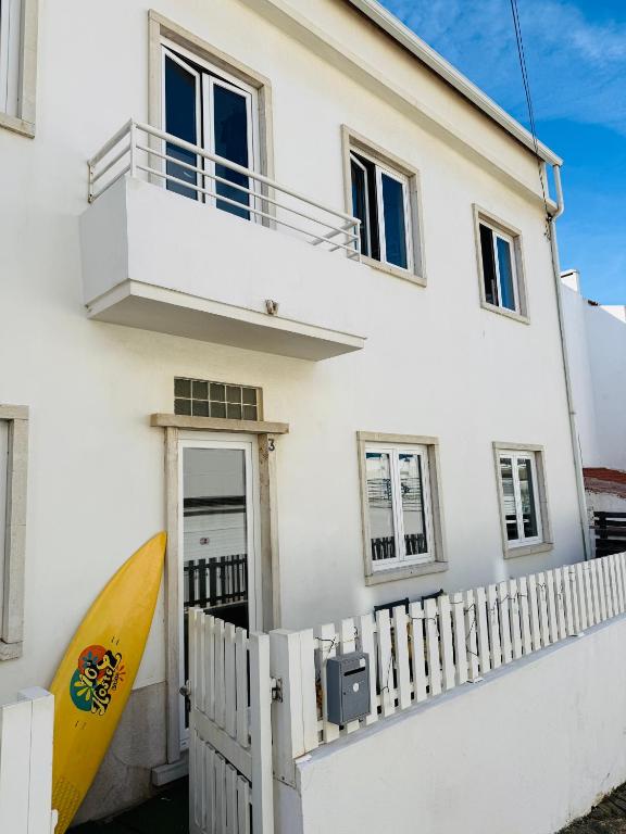 a house with a surfboard in front of it at 70's Hostel in Ericeira
