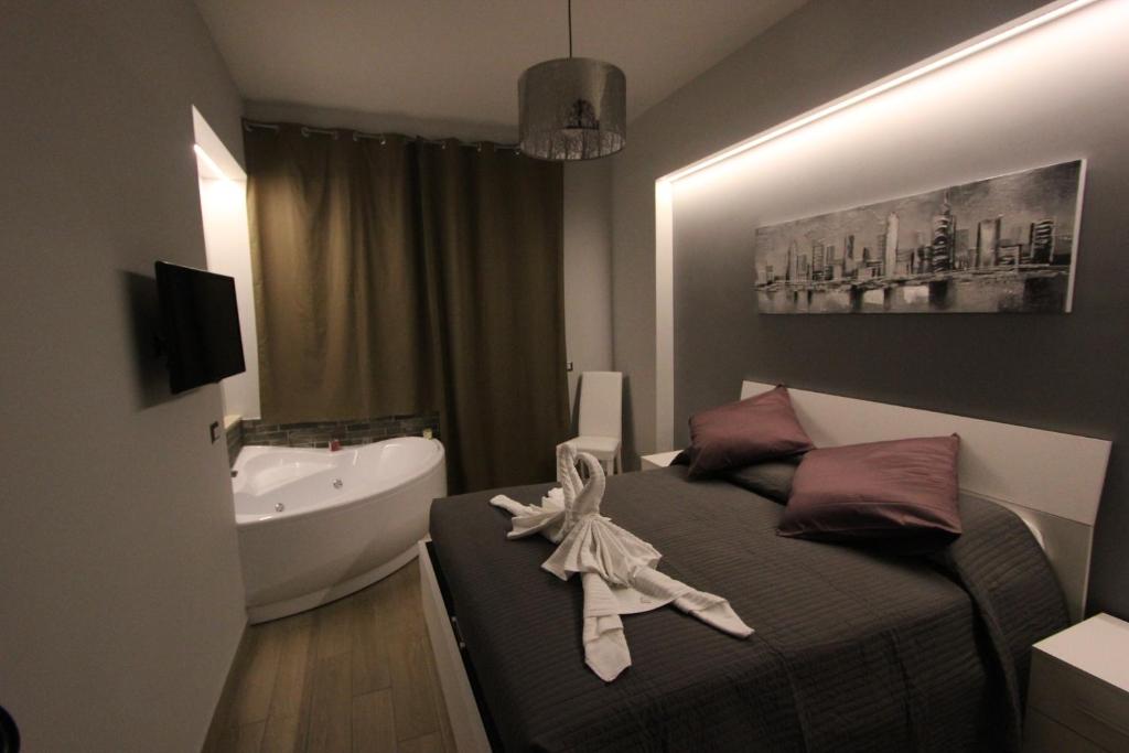1 dormitorio con cama, bañera y lavamanos en Pianeta Roma 127, en Roma