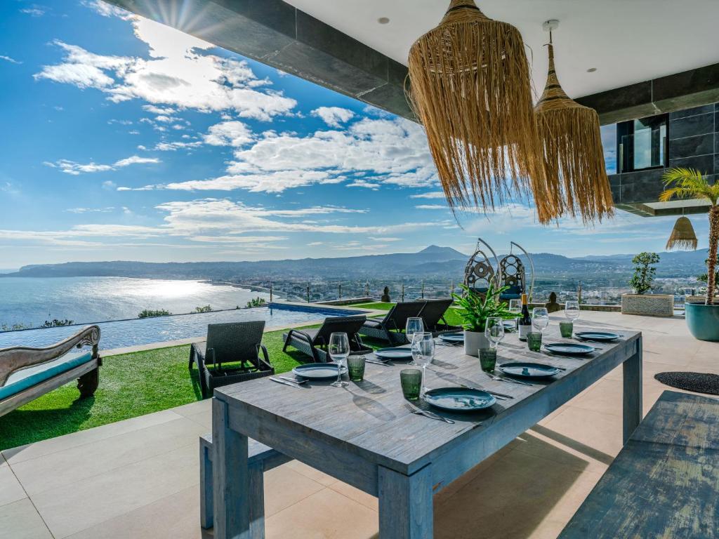 a dining room with a table and a view of the water at Villa Bali Infinity Plus by Interhome in Jávea