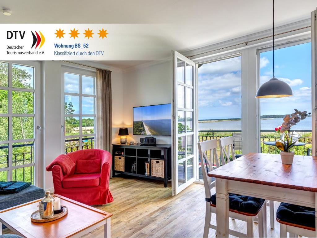 a living room with a dining table and a tv at Residenz am Balmer See - BS 52 mit Wellnessbereich in Balm