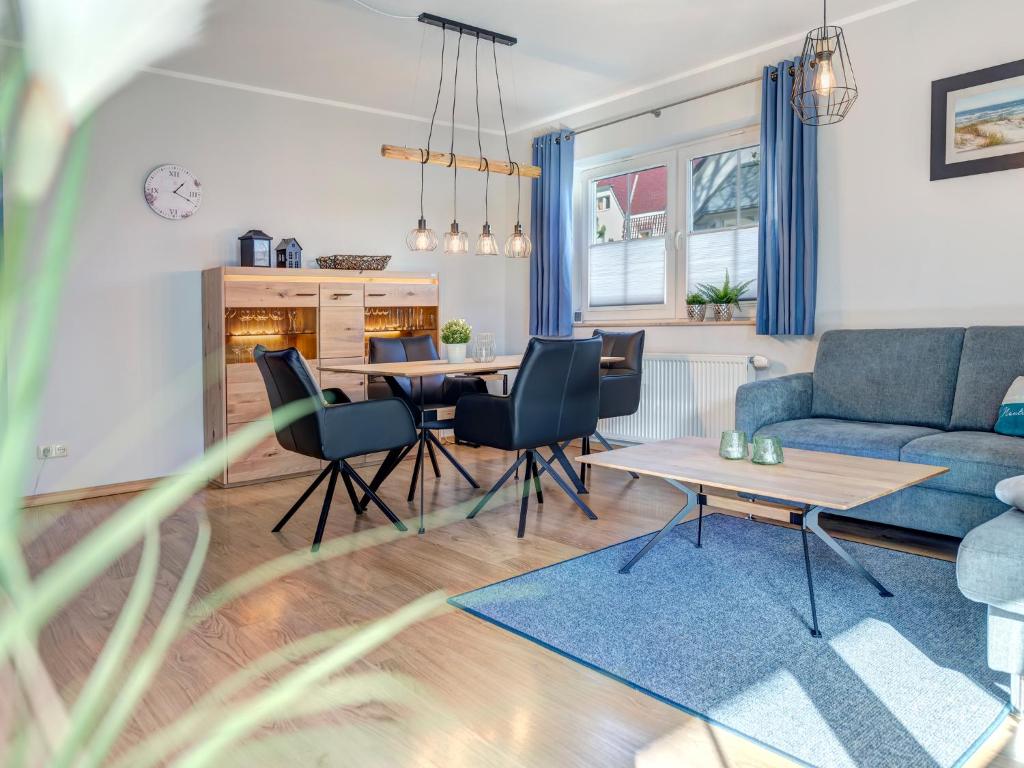 een woonkamer met een blauwe bank en een tafel bij Ferienwohnung Maus in Ostseebad Koserow