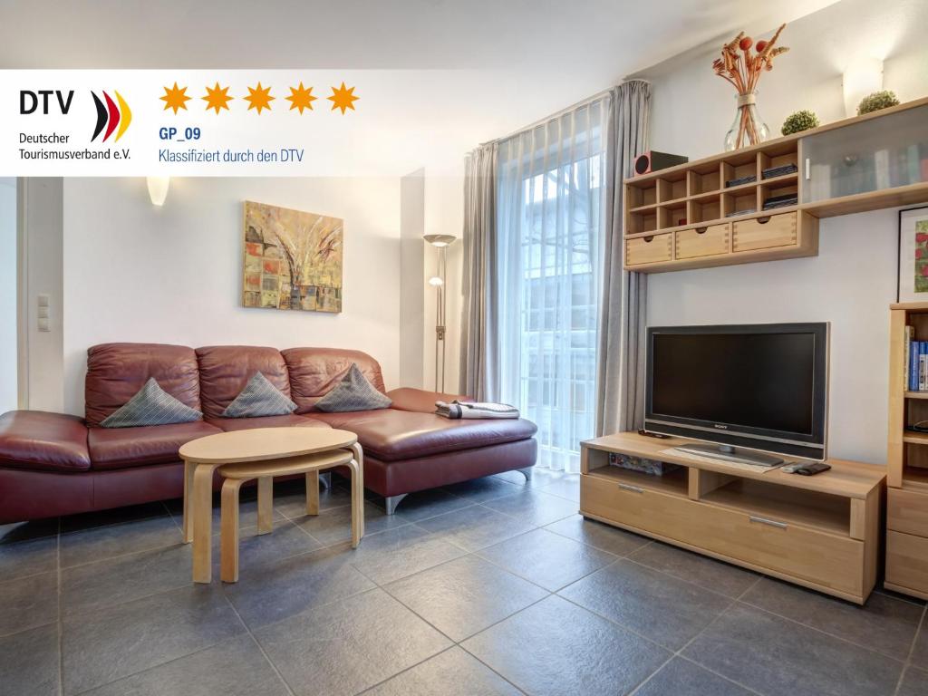 Ostseeresidenz Gorki- Park - 09 mit Wellness und Schwimmbad في بانسين: غرفة معيشة مع أريكة وتلفزيون