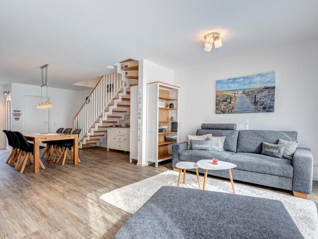 een woonkamer met een bank en een tafel bij Bernsteinquartier BQ6b - Haus Lachmöwe in Kolpinsee