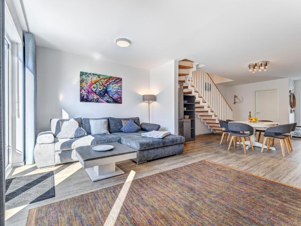 una sala de estar con un sofá y una mesa en Bernsteinquartier BQ 07e - Ferienhaus Meerzeit, en Kolpinsee
