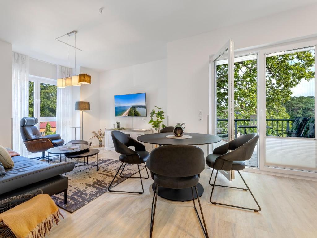 ein Wohnzimmer mit Tisch und Stühlen in der Unterkunft Bernsteinquartier BQ 0558 - Eichenkrone in Ostseebad Kölpinsee