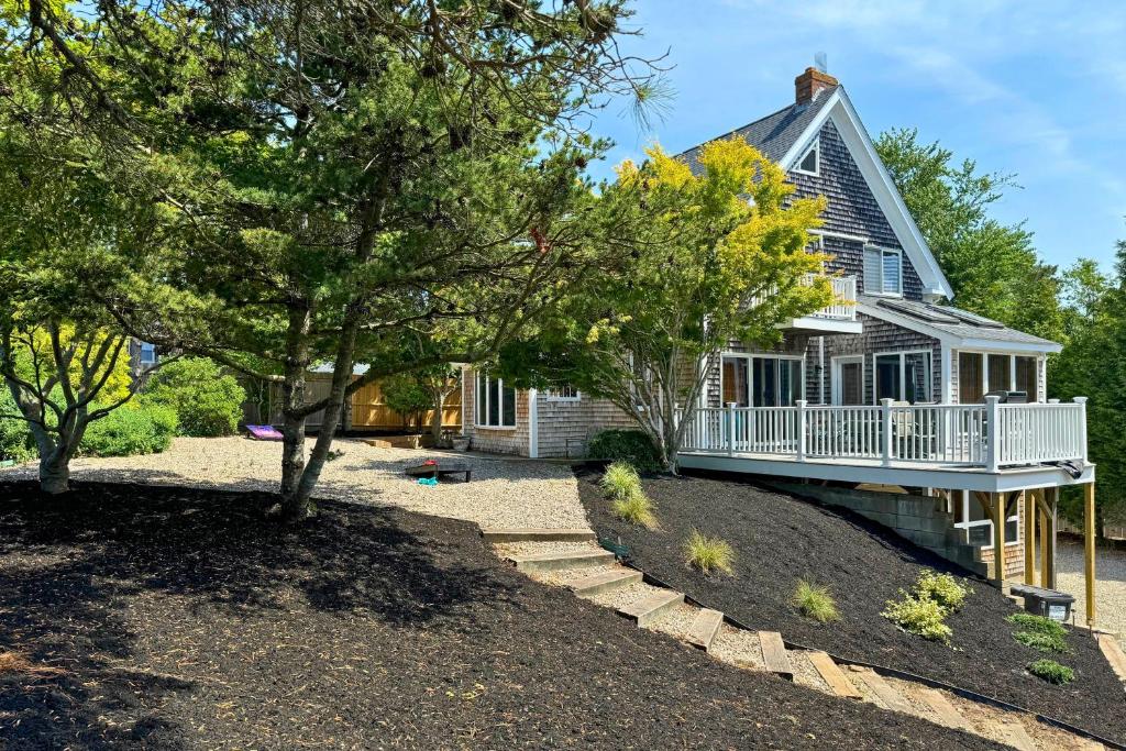 a house with a porch and a yard with trees at Walk to Beach! Hyannis Family Haven w/ Deck in Hyannis