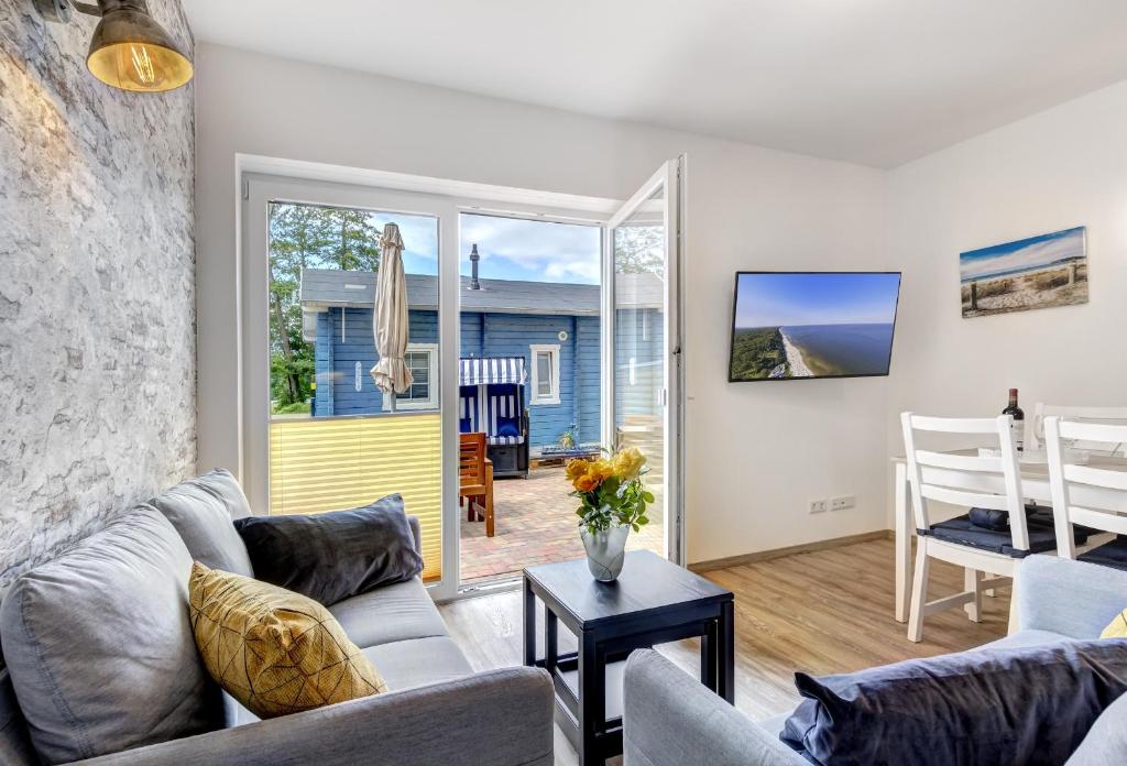 a living room with a couch and a table at Haus Strandkörv mit Fass-Sauna in Loddin