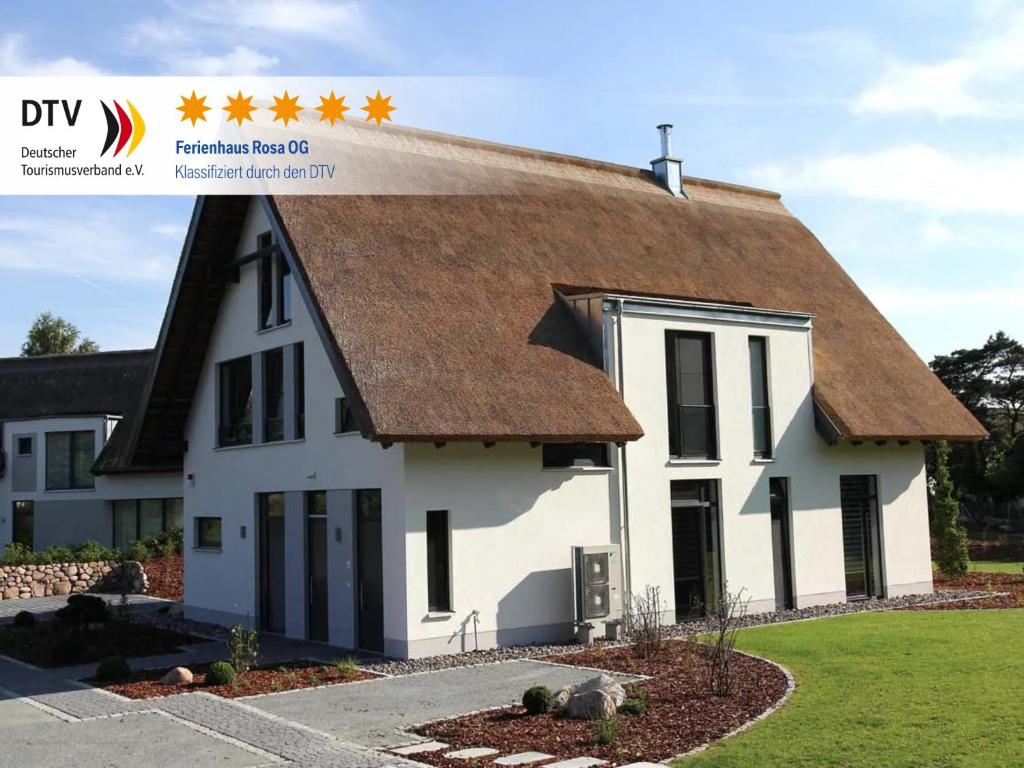 a white house with a brown roof at Ferienhaus Rosa in Ostseebad Karlshagen