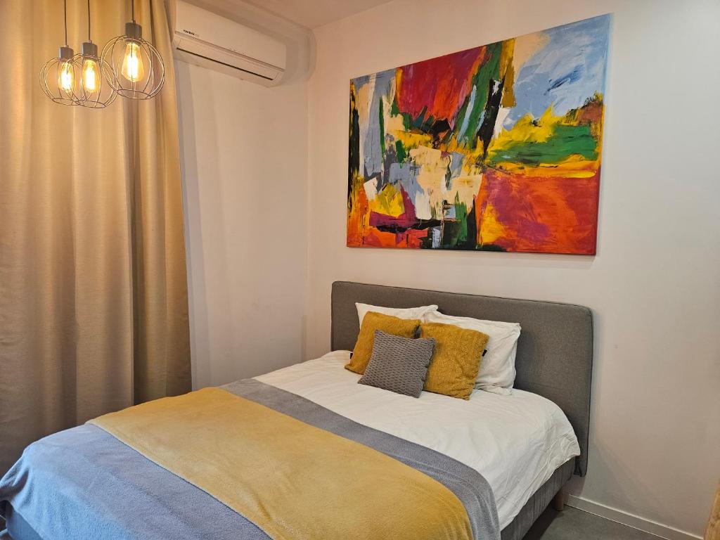 łóżko w sypialni z obrazem na ścianie w obiekcie Ottimo Apartamenty Jagiellońska w Bydgoszczy