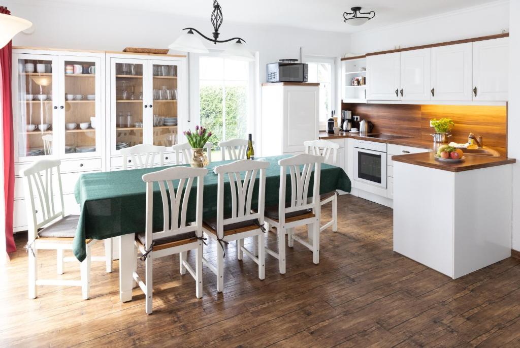 une cuisine et une salle à manger avec une table et des chaises dans l'établissement Meerferienhaus - Haus Schlehenweg, à Zinnowitz
