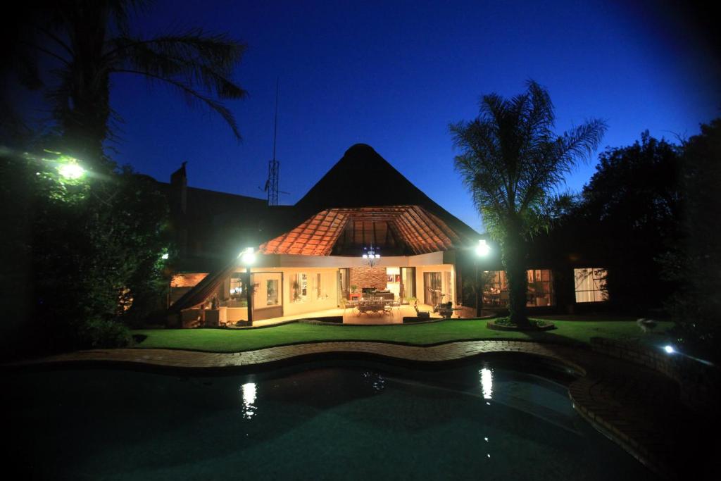 a house with a pool in front of it at night at Andante Lodge in Pretoria